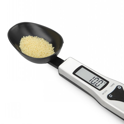 The scoop holding rice, with the display reading 10.0 grams