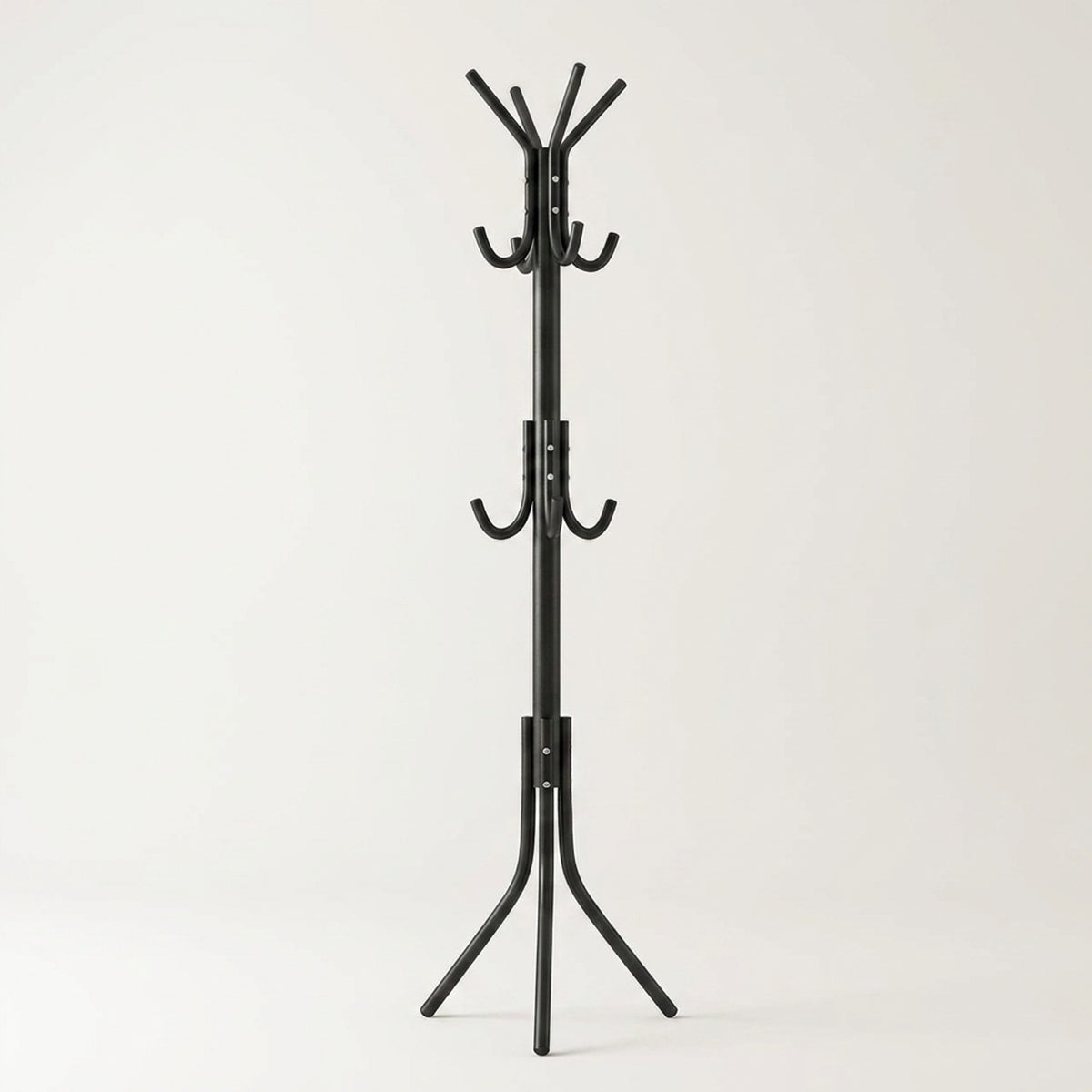 The black coat rack, empty, standing on its tripod base